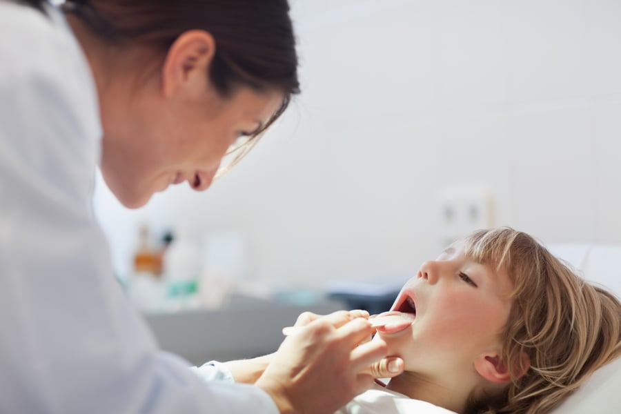 Doctor looking inside the mouth of a child at the dentist