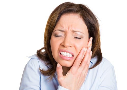 Closeup portrait, mature woman with sensitive tooth ache crown problem about to cry from pain touching outside mouth with hand, isolated white background. Negative emotion facial expression feeling