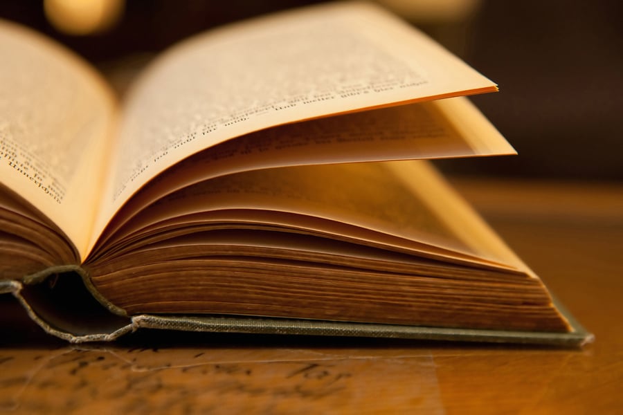 Open old book with warm light on a table