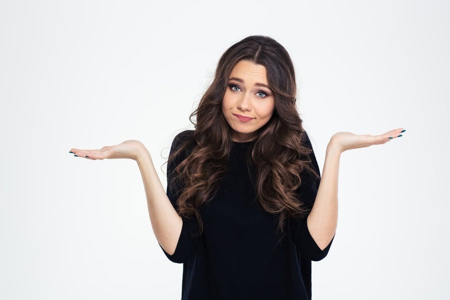 Portrait of a pretty woman shrugging shoulders isolated on a white background