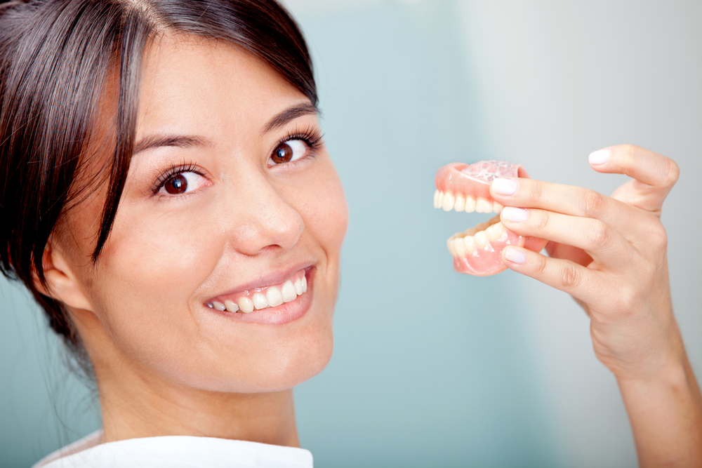 woman holding dentures