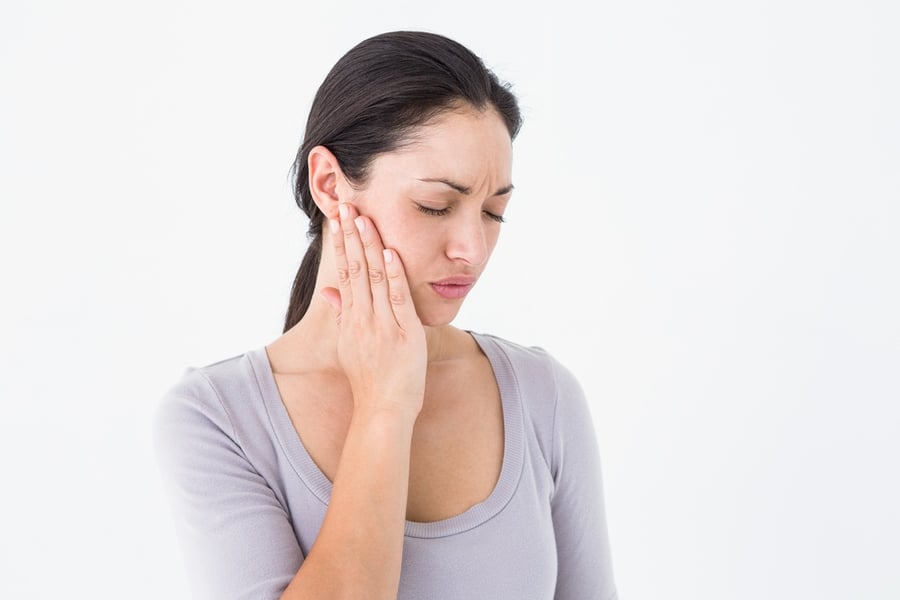 Woman suffering from teeth pain on white background