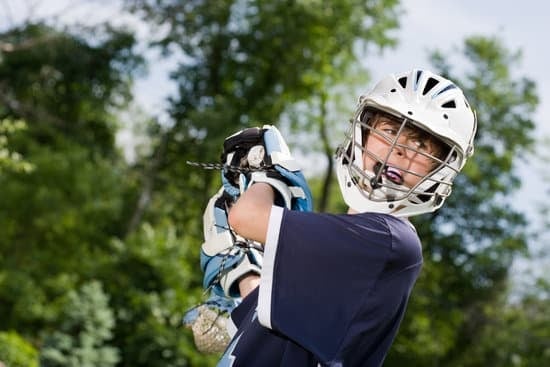 Boy Playing lacrosse wearing a helmet and mouthguard.