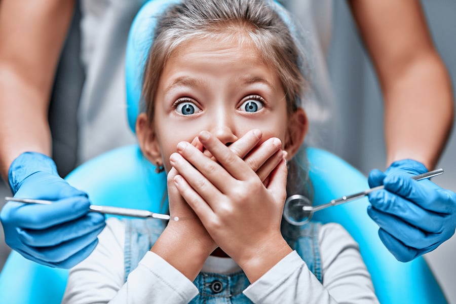 Girl covering her mouth from the dentists