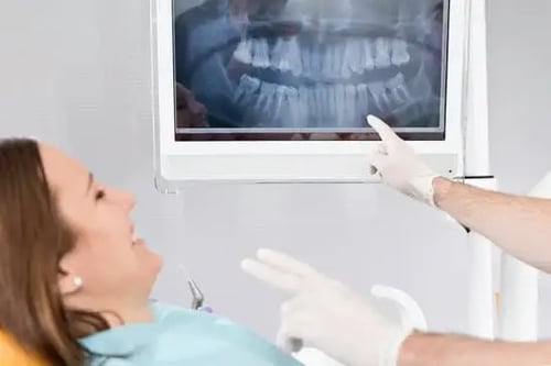 Woman at the oral surgeon looking at x-ray