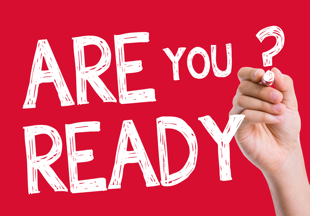 hand with pen writing the words "are you ready"