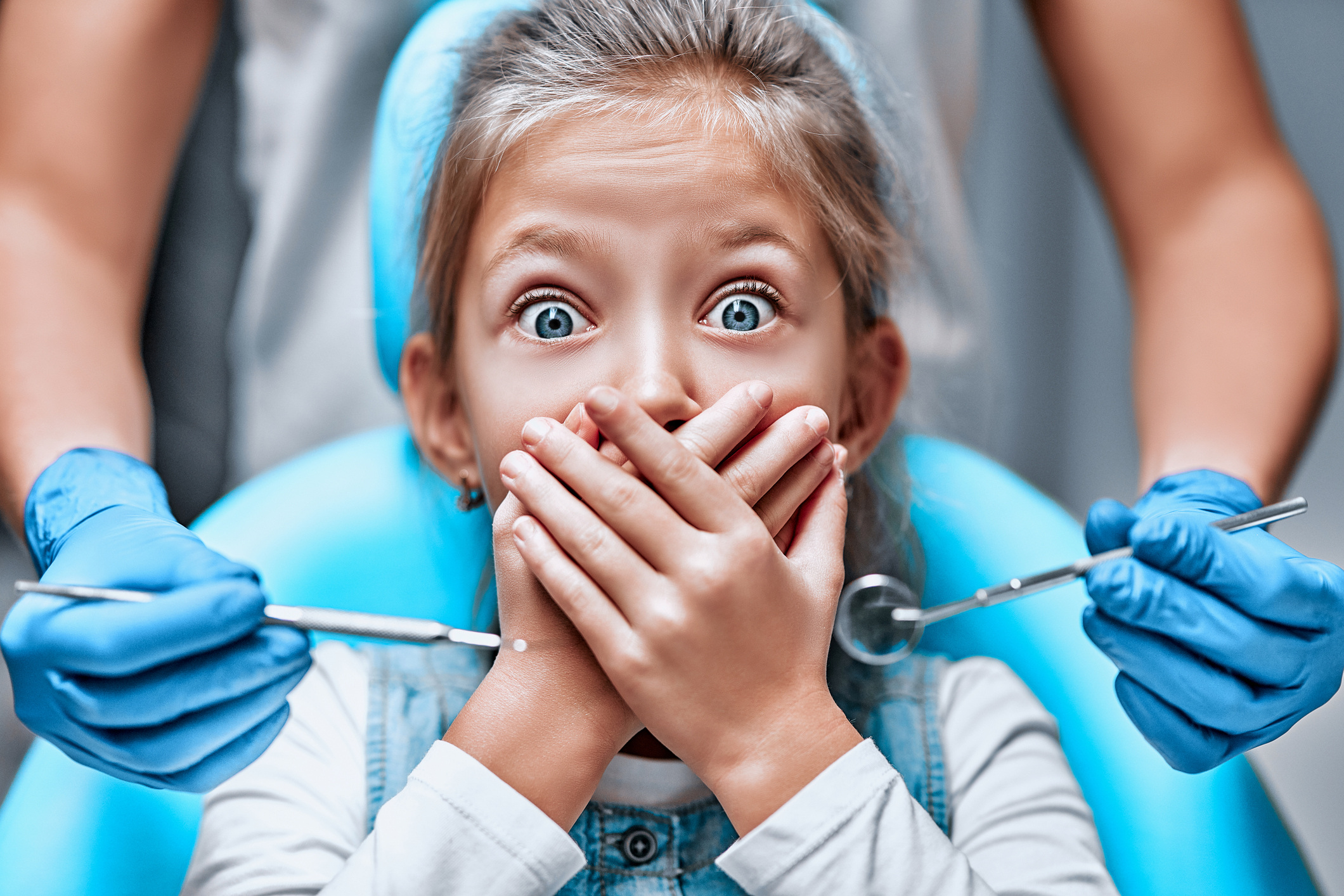 Girl covering her mouth from the dentists